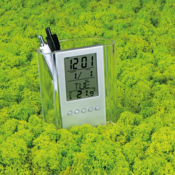 porta lapiceros plástico transparente con reloj en fondo pasto verde merchandising